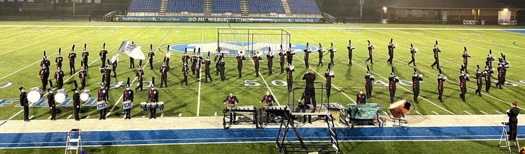 the marching band on the field marching a show formation